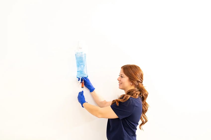 Hydration Room Nurse Injecting Vitamins Into IV Bag