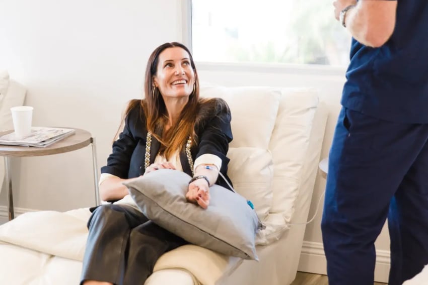 Hydration Room Patient Happily Receiving IV Therapy and Talking With Nurse