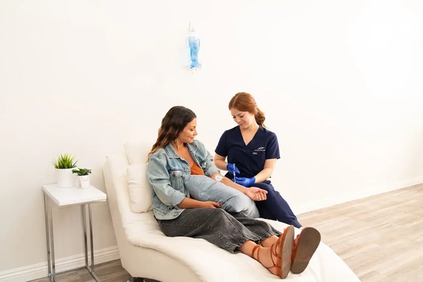Hydration Room Patient Watching as Nurse Injects Vitamins 