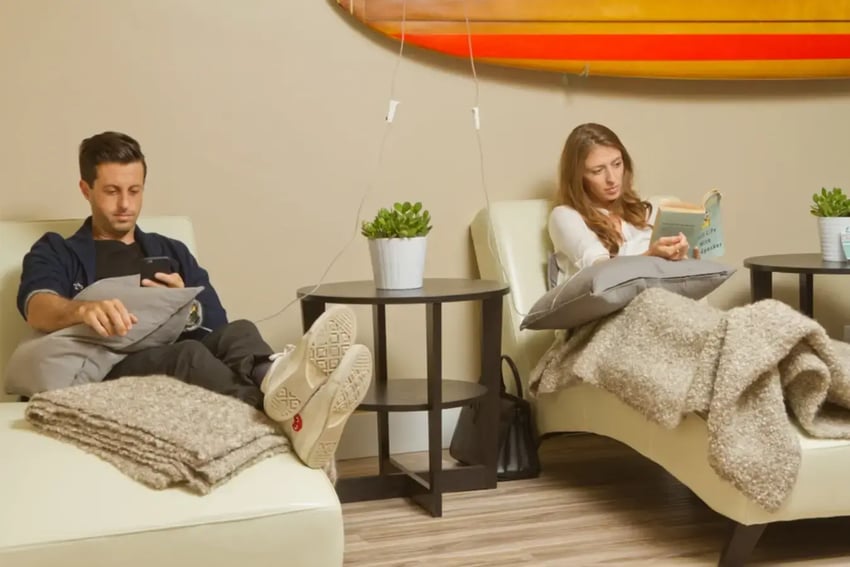 Hydration Room Patients Reading a Book and Relaxing While Receiving IV Therapy 