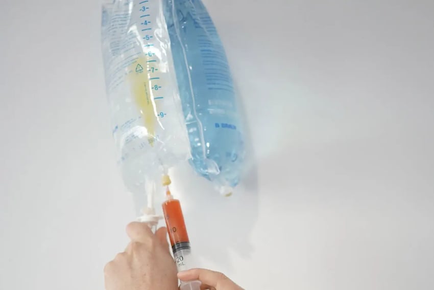 Hydration Room Vitamins Being Inserted Into IV Fluid Bag