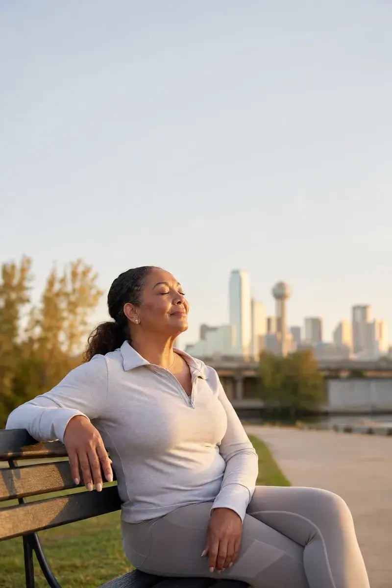 Woman relaxing outdoors at golden hour, calm and rested
