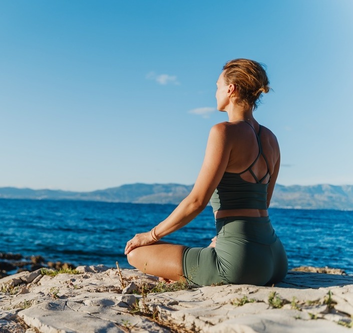 Woman doing yoga at the beach