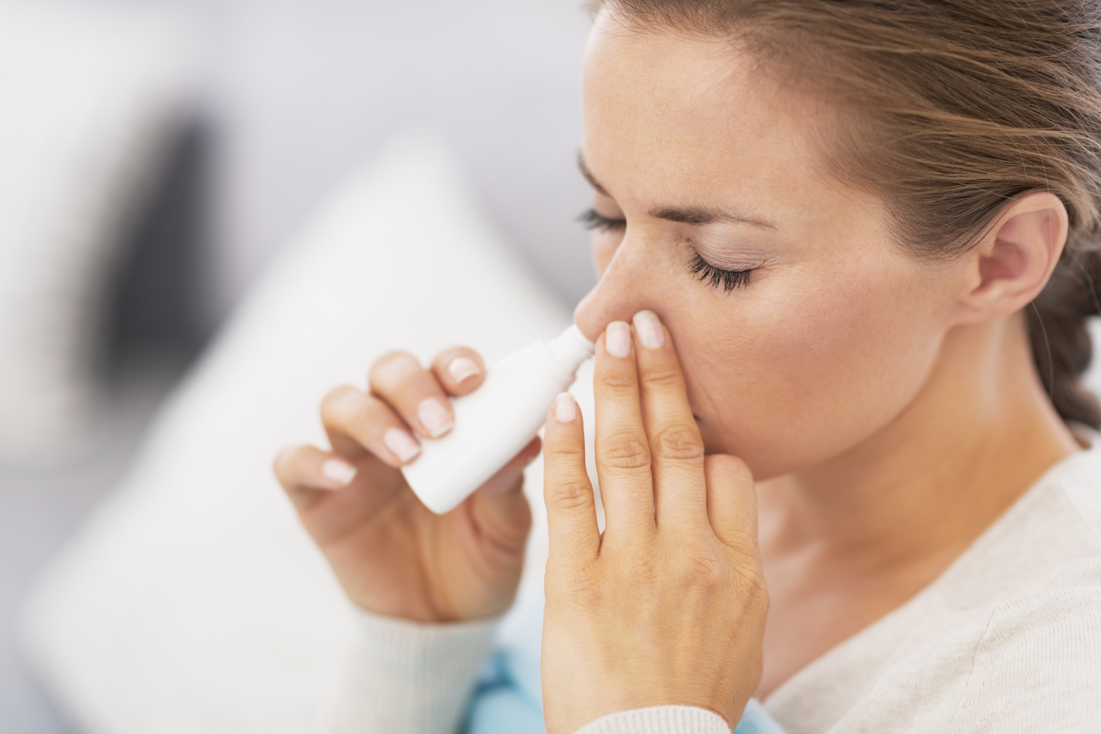 A woman using a nasal spray