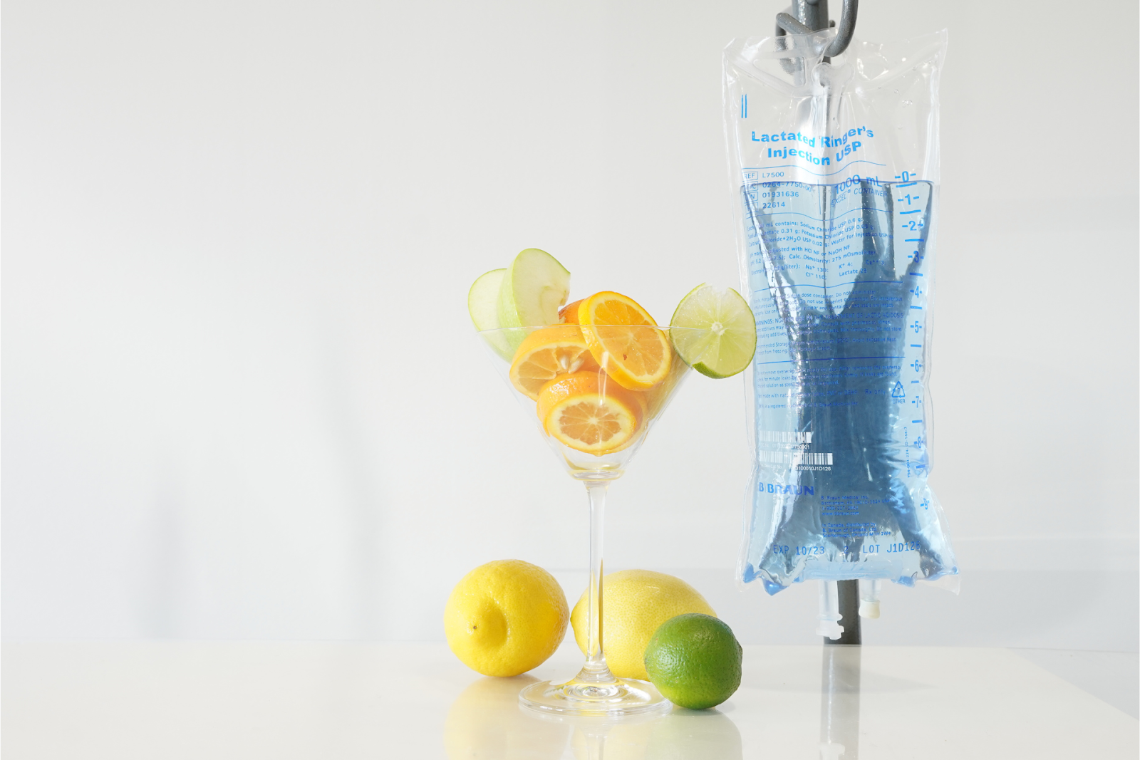  IV hydration bag displayed beside fresh citrus fruit on a clean white surface