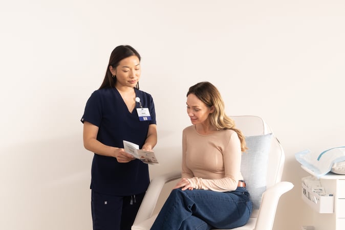 A medical professional from the Hydration Room explaining vitamin IV therapy benefits to a woman