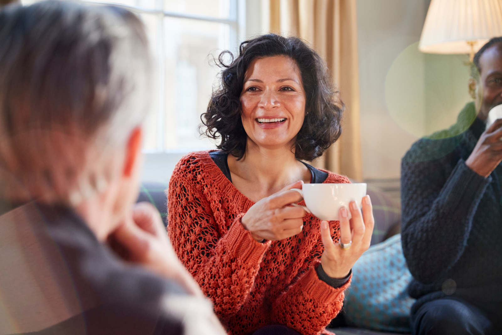 A middle-aged woman with great skin, having coffee with friends
