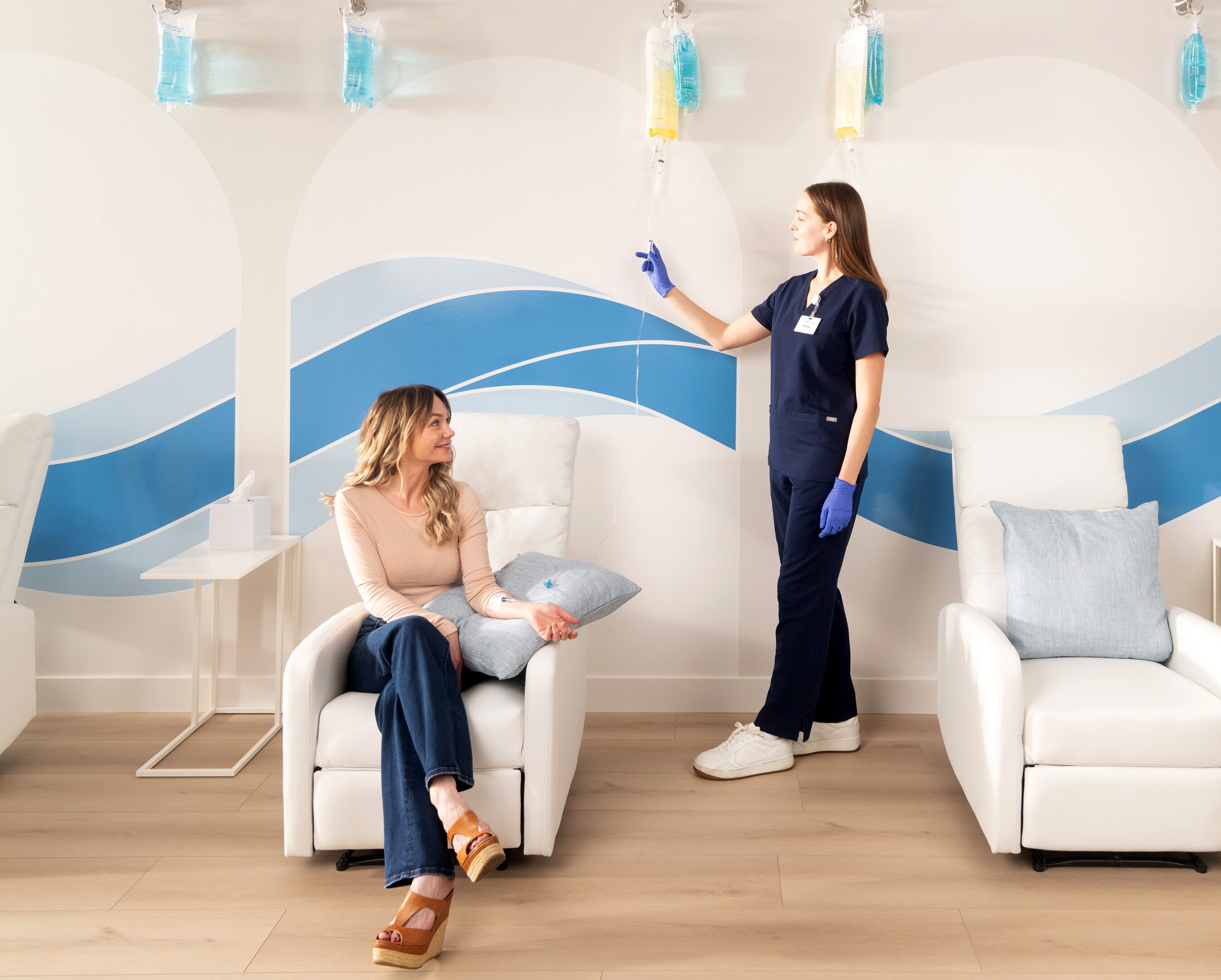 Happy woman getting an IV from a nurse at a clinic.