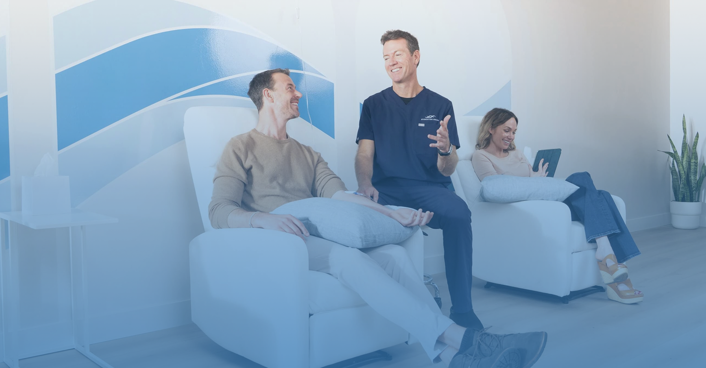 Happy man getting an IV from a nurse at a clinic.