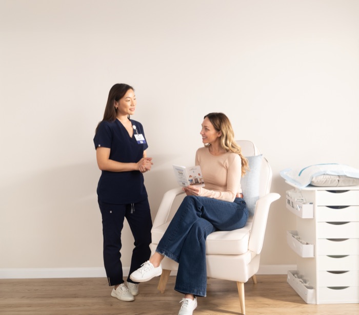 Nurse speaking with a seated patient during an IV session